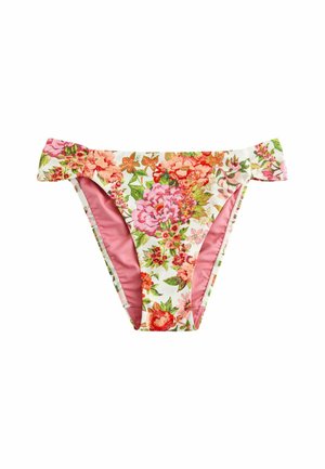 Nahaufnahme einer Person, die geblümte Bikinihöschen mit einer Hand auf der Hüfte anpasst und dabei die Details der Bademode und die Hautstruktur hervorhebt.