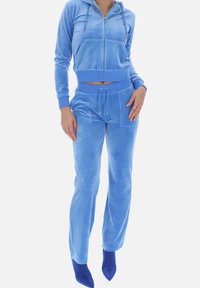 Ensemble en velours à deux pièces de couleur bleu clair. Le hoodie possède une poche avant ; le pantalon a deux grandes poches et une taille à cordon de serrage ; design ajusté pour les jambes.