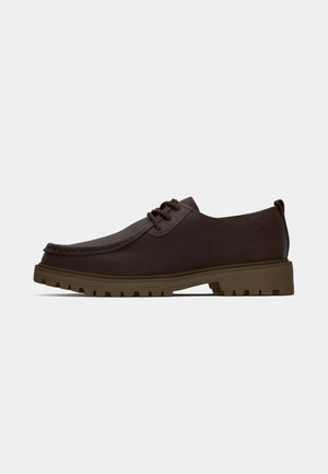 Pantofi din piele maro cu șireturi, cu vârful rotunjit, cusături detaliate și o talpă din cauciuc rezistentă, având un model de tread texturat.