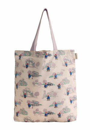 Beige tote bag with pink handles and repeated pattern of blue-cloaked bear wearing a red hat, cityscapes, trees, cars, and buses.