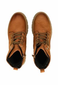 Botas de tobillo de cuero marrón con acabado texturizado, puntera redonda y ojales de metal. Presentan cordones y una pestaña en el talón.