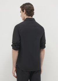 Schwarzes Langarmshirt mit glatter Textur, hochgekrempelten Ärmelbündchen und Kragen, mit abgerundetem Saum und minimalistischem Design.