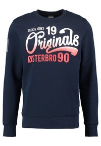Námořnická modrá mikina vyrobená z bavlněné směsi. Má dlouhé rukávy, kulatý výstřih a grafický potisk v bílé a červené barvě s nápisem "Originals Østerbro 90."