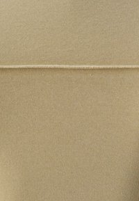 Beige ribbat tyg med en slät yta, med en horisontell söm tvärs över mitten. Enkelt och omtänksamt mönster.