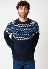 Dunkelblaues Sweatshirt mit einem geometrischen Muster in Weiß und Blau auf der Schulterpartie. Runder Halsausschnitt und gerippte Bündchen, aus strukturiertem Strickmaterial gefertigt.
