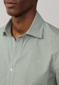 Camicia a quadri verde e bianca con colletto a bottoni, caratterizzata da una trama texturizzata e da una vestibilità comoda.