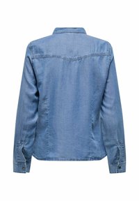 Chemise en denim à manches longues de couleur bleu clair, avec un col, un ourlet droit et des poignets à boutons. Texture lisse et design décontracté.