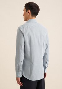 Camicia a quadri blu chiaro con polsini a bottoni e colletto classico. Tessuto di cotone con una texture liscia e orlo curvo sul retro.