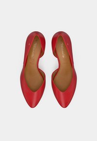 Κόκκινα δερμάτινα φλατ παπούτσια με μυτερή μύτη, χαμηλές πλαινές πλευρές και λεία υφή. Το εσωτερικό έχει ανοιχτό καφέ πάτο με σήμανση.