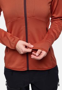 Giacca rustica, textured con una cerniera frontale, maniche lunghe e polsini regolabili. Presenta tasche laterali e un design aderente.