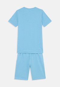 Ensemble en coton bleu clair composé d'un T-shirt à manches courtes avec un col rond et d'un short assorti avec une taille élastique.