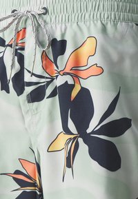 Săritură de baie verde deschis cu modele florale negre și portocalii, având un brâu elastic și un șnur de contrast. Textură netedă.