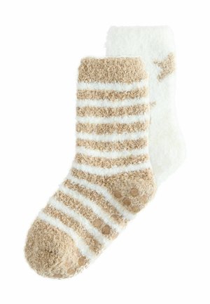 Et par fuzzy ankelstrømper, den ene beige med hvide striber og gribepunkter, den anden hvid med beige stjernemønstre.