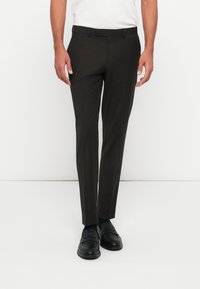 Mørkebrune dressbukser med en jevn tekstur, slim fit og flat front. Har beltehemper i midjen og subtile sømdetaljer.