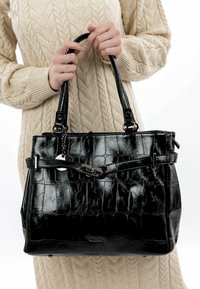 Sac à main en cuir noir gaufré crocodile avec deux poignées supérieures, un fermoir à l'avant et un accent en argent. Surface texturée avec une forme structurée.
