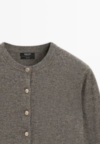 Cardigan in lana grigia con collo rotondo, cinque bottoni metallici sul davanti e finitura a maglia testurizzata. L'etichetta indica materiale 100% lana.