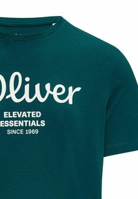 Türkisfarbiges Baumwoll-T-Shirt mit kurzen Ärmeln. Mit weißem Text: "Oliver" über "ELEVATED ESSENTIALS" und "SINCE 1969" in fetter Schrift.
