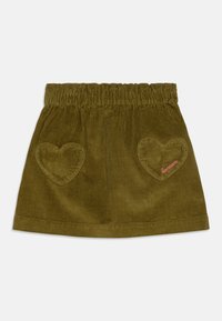 Grønn cordfløyelskjøtt med elastisk linning, to hjerteformede lommer, og rosa broderte "bonson"-tekst på en lomme.