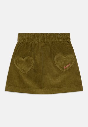 Grønn cordfløyelskjøtt med elastisk linning, to hjerteformede lommer, og rosa broderte "bonson"-tekst på en lomme.