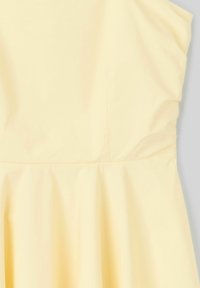Robe sans manches jaune avec un corsage ajusté et une jupe évasée. Texture douce avec de légères fronces à la taille, affichant une encolure nette.