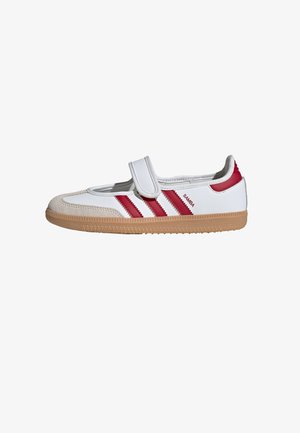 Zapatilla Adidas Samba blanca y roja con cierre de velcro, suela de goma y puntera de ante mostrada de perfil.