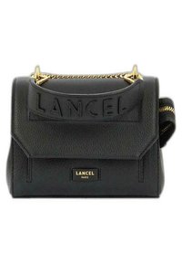 Sac à main en cuir noir avec une surface texturée, quincaillerie dorée, logo embossé et une sangle accentuée de chaînes, avec une poche latérale zippée.