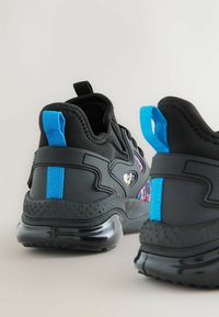 Black athletic shoes with a textured upper, featuring a blue pull tab, colorful patterns on the side, and a glossy black outsole.