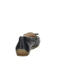 Zapato negro de piel sin cordones con un tacón redondeado y una suela de goma flexible. Presenta acentos de costura y una textura suave y lisa.