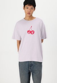 Lila T-shirt met korte mouwen, gemaakt van zachte katoen, met een rode kersafbeelding en het nummer 80 gecentreerd op de borst. Casual pasvorm.