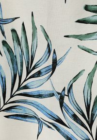 Tissu avec un motif de feuilles vertes et bleues allongées sur fond crème, affichant une texture lisse et un design botanique.