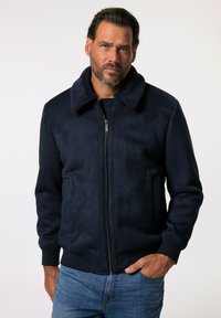 Marineblaue Bomberjacke mit Reißverschluss, flauschigem Kragen und gerippten Bündchen. Glattes Material mit leicht glänzendem Finish.