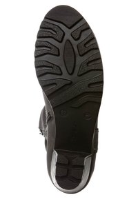 Suela de zapato de goma negra con patrones texturizados contrastantes; presenta un diseño de tacos para tracción y un acento suave cerca del talón.