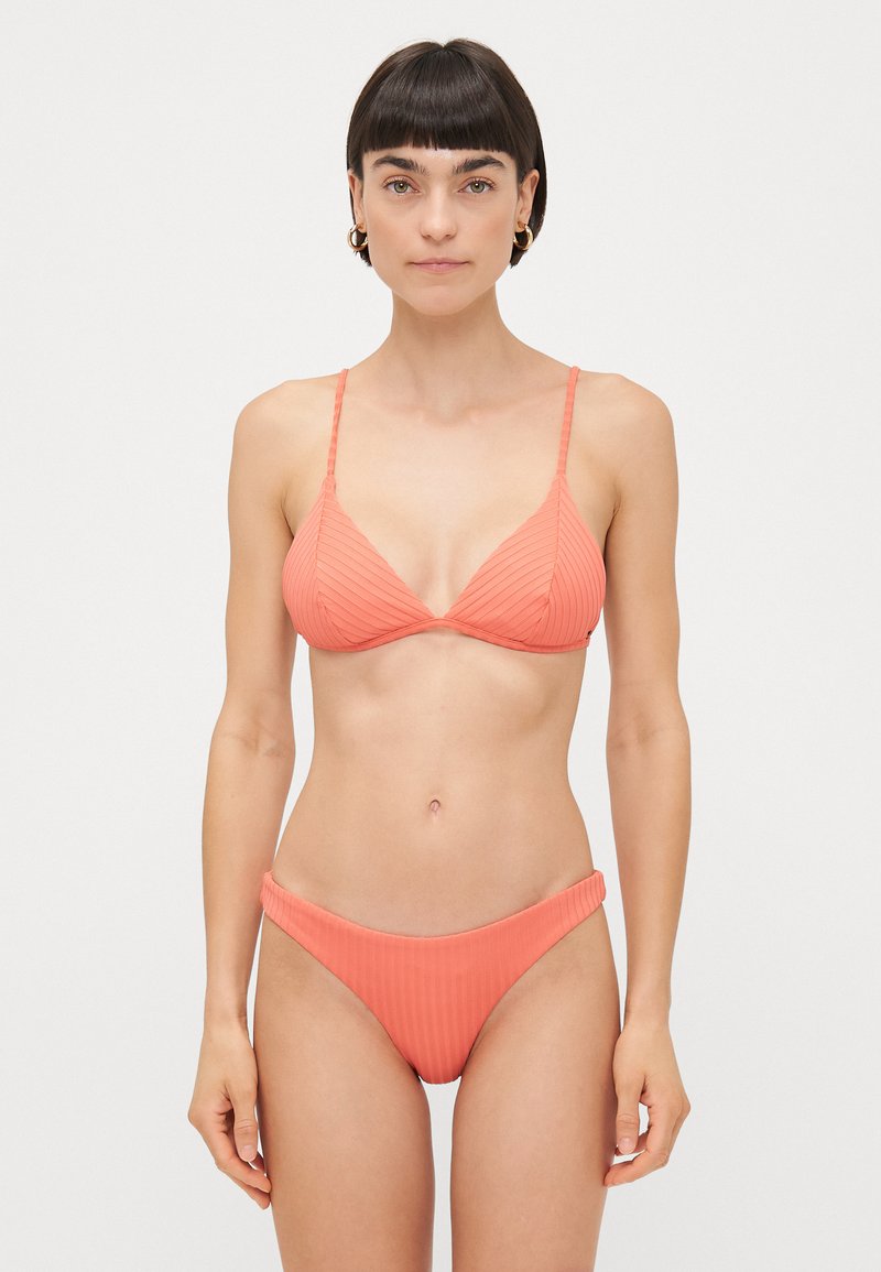 Coral ribbed bikini set featuring a triangular bralette with thin straps and matching high-waisted bottom, both made from stretchy fabric.