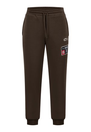 Hnědé tepláky s elastickým pasem a manžetami. Na boku jsou znaky a nášivka pro zvýšení designu. Měkká textura.