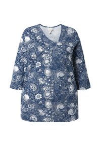 Blaue Bluse mit langen Ärmeln, weißen Blumen- und Wirbelmustern sowie einem runden Ausschnitt mit einer kleinen V-förmigen Kerbe.