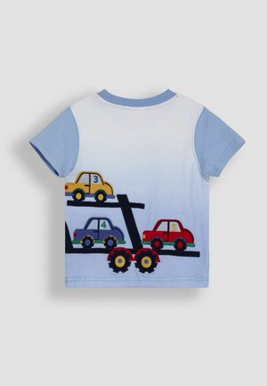 Lyhythihainen puuvillapaita vaaleansinisessä värissä, jossa on mustaan kuorma-autokuvaan brodeeratut värikkäät autot. Pehmeä ja sileä rakenne.