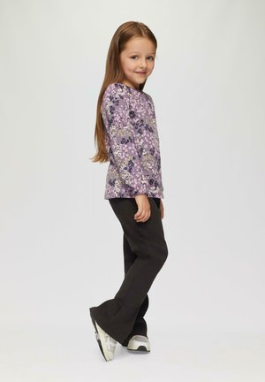 Langärmliges lila Oberteil mit floralem Muster, kombiniert mit dunklen Hosen und Sneakern. Es hat einen lässigen Schnitt und ein Rundhalsdesign.