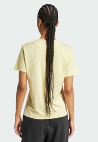 Kurzärmliges gelbes Sportshirt mit glatter Textur, rundem Ausschnitt und kontrastierenden Nähten an den Schultern.