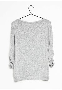 Szary top z długim rękawem o luźnym kroju. Miękka, teksturowana tkanina z marszczonymi rękawami i szerokim dekoltem. Zawieszony na czarnym haczyku.