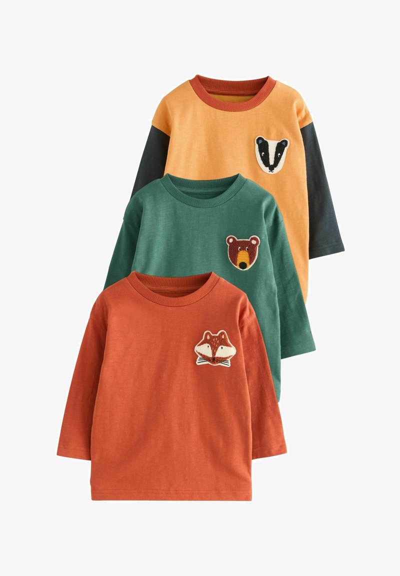 Tre magliette per bambini a maniche lunghe in arancione, verde e giallo, ciascuna con una toppa con la faccia di un animale di una volpe, un orso e un tasso sul petto.