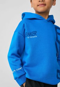 Felblau hoodie met de tekst "BAKER", gemaakt van zacht katoen, grote voorzak en mouwdetail met coördinaten.