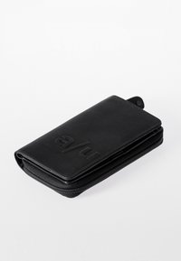 Black leather wallet with a zipper closure, embossed logo on the front, smooth texture, and a sleek rectangular shape.