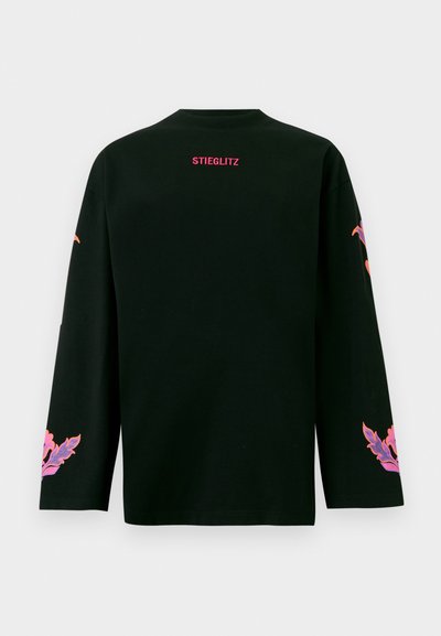 Fekete, hosszú ujjú póló kerek nyakkivágással. A hátrészén rózsaszín "STIEGLITZ" felirat, az ujjakon pedig színes virágminták találhatók.