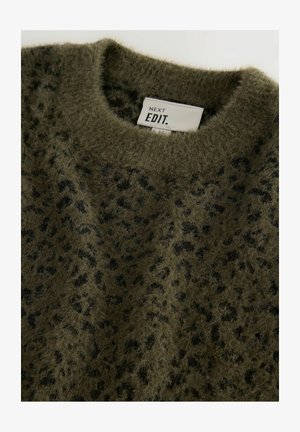 Vihreä pörröinen neule, jossa on pyöreä kaula-aukko ja mustia leopardikuvioita. Kangas näyttää pehmeältä ja siinä on teksturoitu pinta. Lapun näkyvissä.