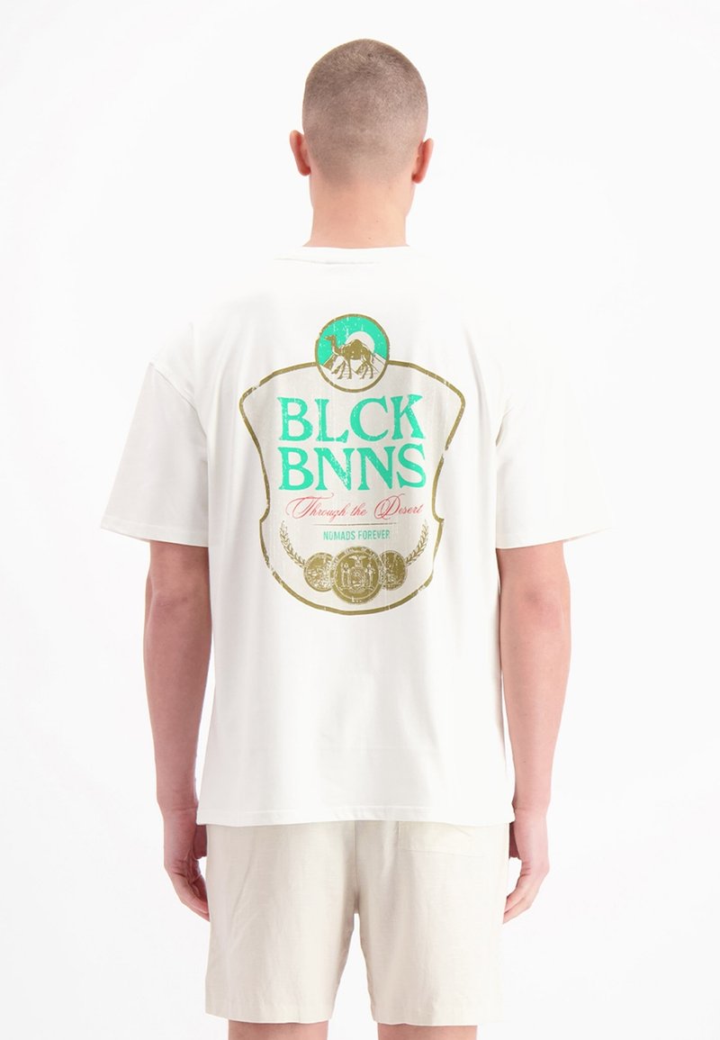 Witte katoenen T-shirt met een grote kleurrijke afbeelding op de achterkant met tekst, een kameel en decoratieve elementen. Korte mouwen, relaxte pasvorm.