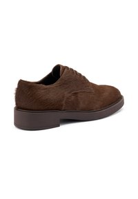 Zapatos de vestir marrones con textura de pelo sintético, puntera redondeada y suela baja marrón. Presentan un diseño clásico de cordones.