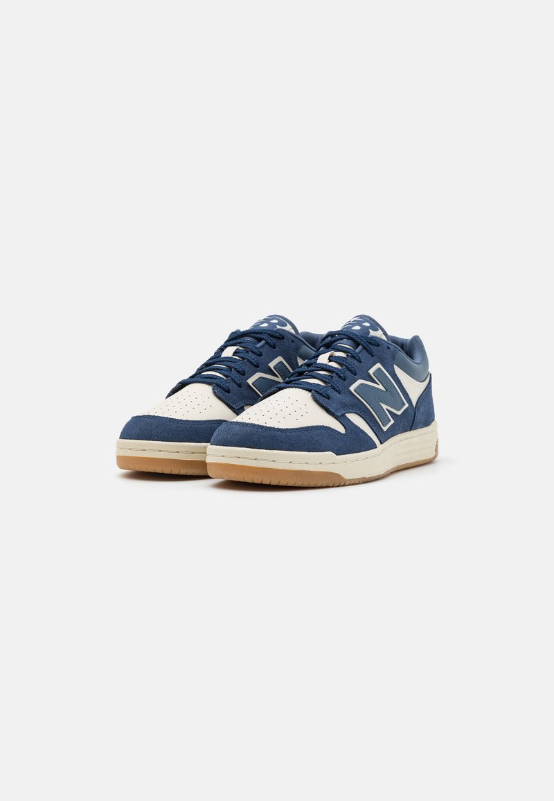 Blaue und weiße Sneakers aus Wildleder und Leder, mit einem perforierten Zehenbereich, Schnürsenkeln und einer Gummisohle. Großes 'N'-Logodesign.