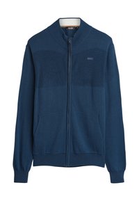 Donkerblauwe ritstrui met ribbelstructuur op de borst, zijzakken en een contrasterende witte kraag. Gladde stofafwerking.