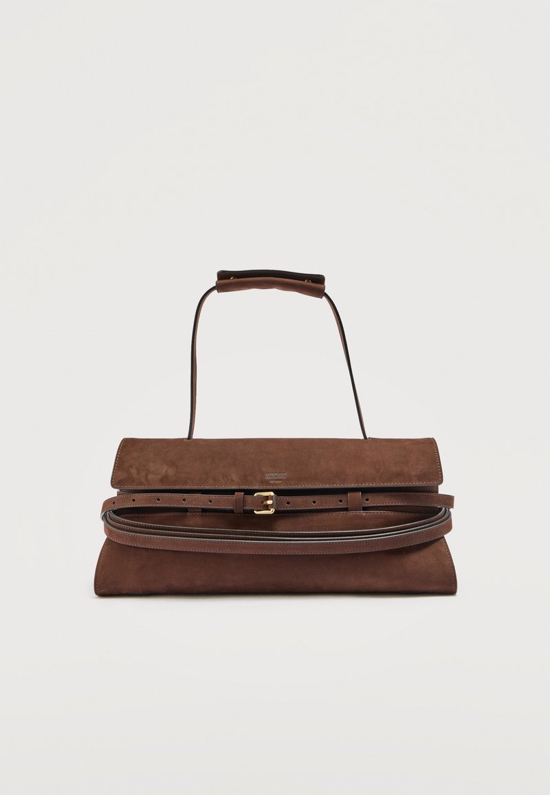 Καφέ τσάντα χειρός από σουέντ με καπάκι, λεπτό λουράκι και ρυθμιζόμενη ζώνη, σε απλό φόντο.