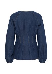 Tume sinine denimpaariga pluus, mis on kitsenenud talje, puhvse varrukate ja õmblusdetailidega. Õmblused on nähtavad servadel ja õmblustes.